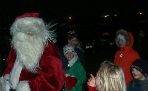 Kveikt á ljósum jólatrésins við árbakkann